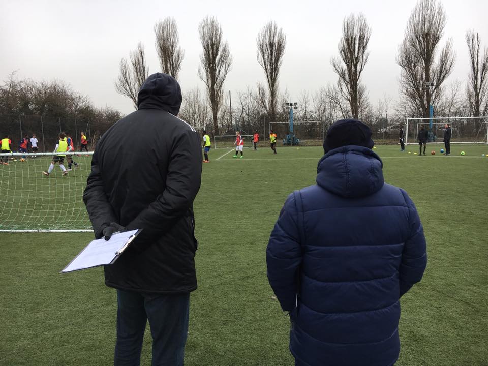 Football scouts watching children play 